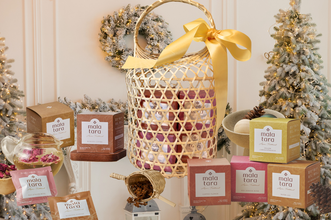 Mala Tara holiday tea products arranged with woven basket, ornaments, and Christmas trees.