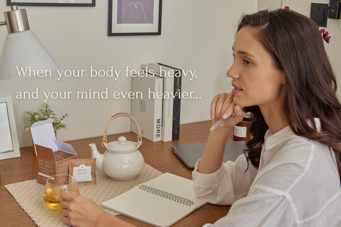 Woman sipping Mala Tara Water Lily Tea while journaling, with text overlay about feeling mentally and physically heavy.